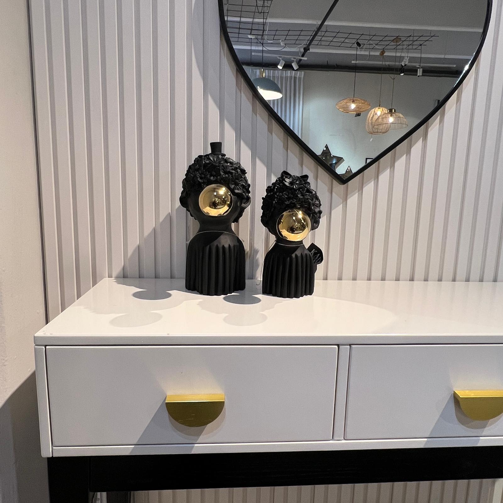 פסל ילד שיער פרחים ופקק זהב בפה שחור פסל ילד שיער פרחים ופקק זהב בפה שחור