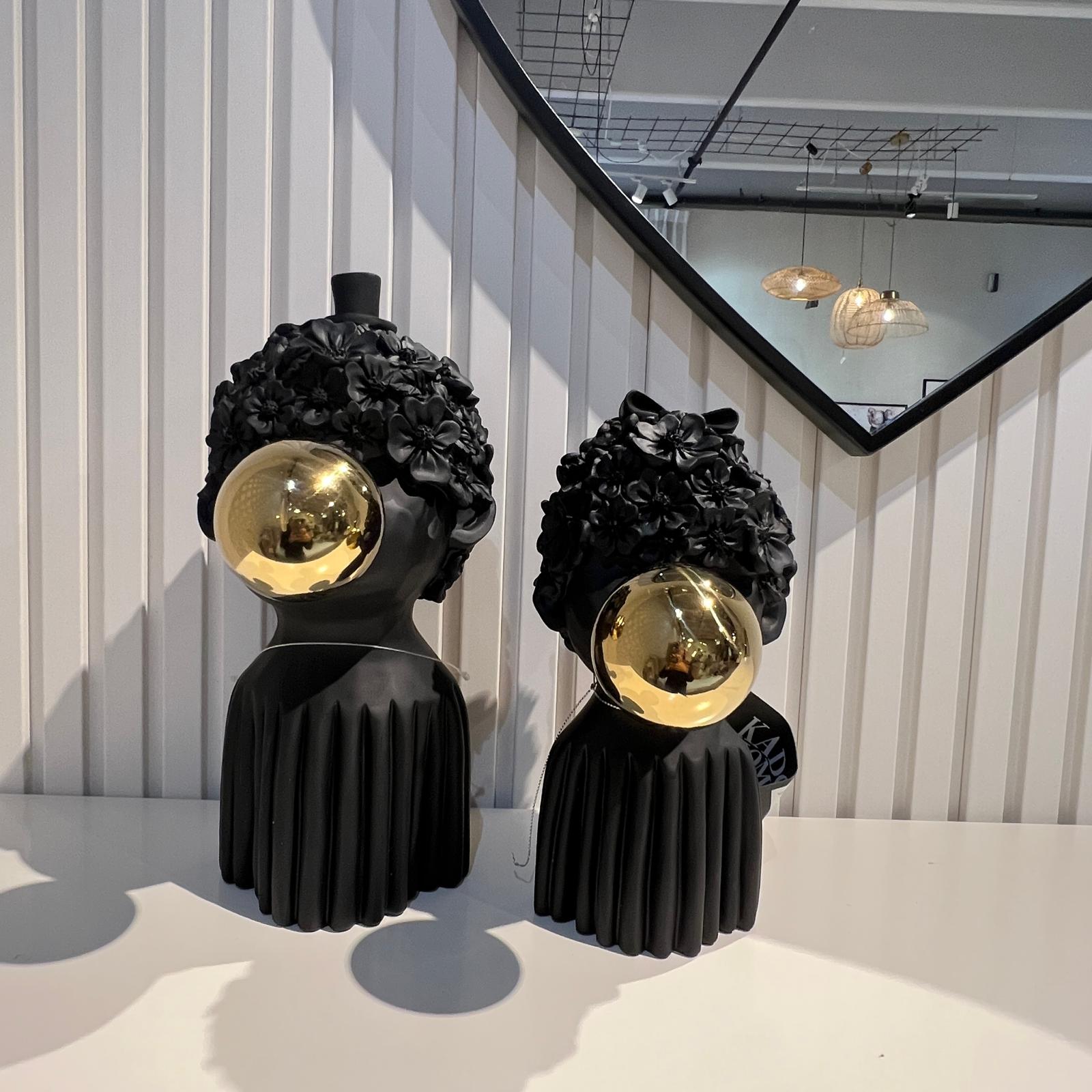 פסל ילד שיער פרחים ופקק זהב בפה שחור פסל ילד שיער פרחים ופקק זהב בפה שחור