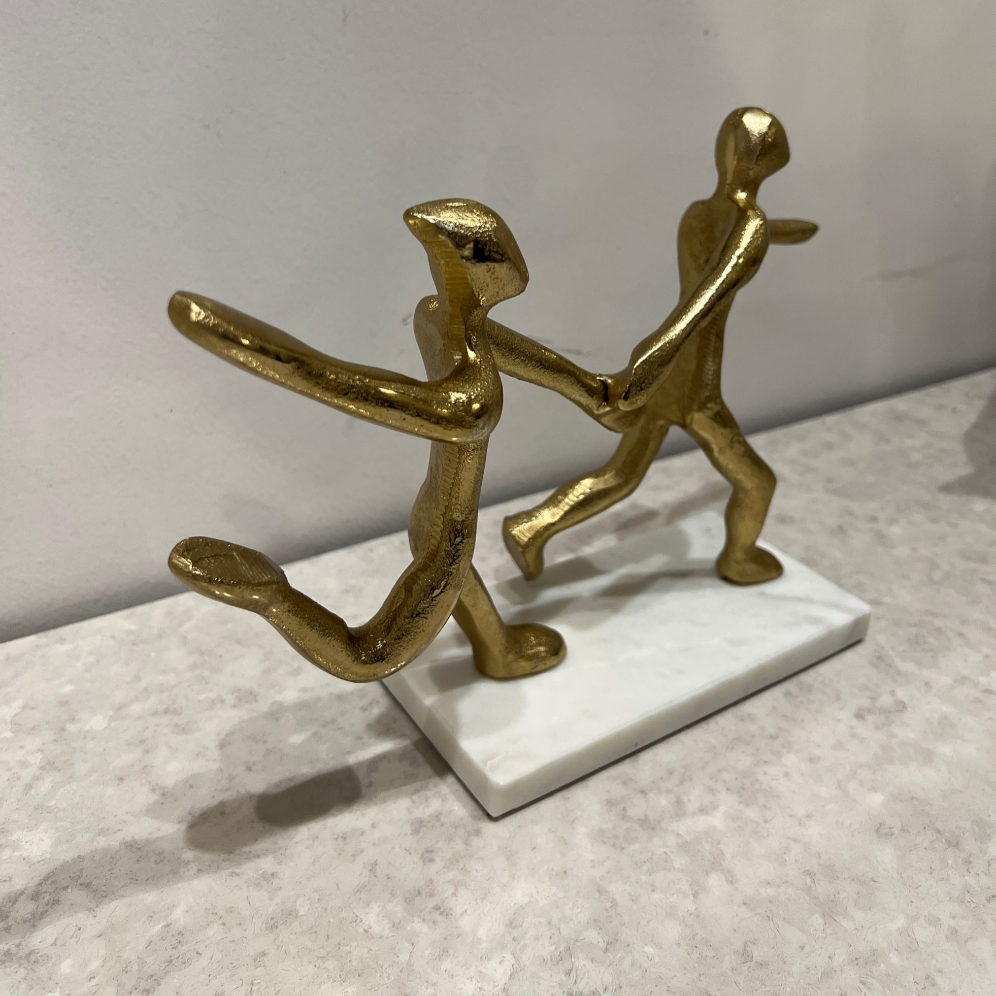 פסל זוג צוהל מזיקים ידיים מתכת זהב בסיס לבן פסל זוג צוהל מזיקים ידיים מתכת זהב בסיס לבן