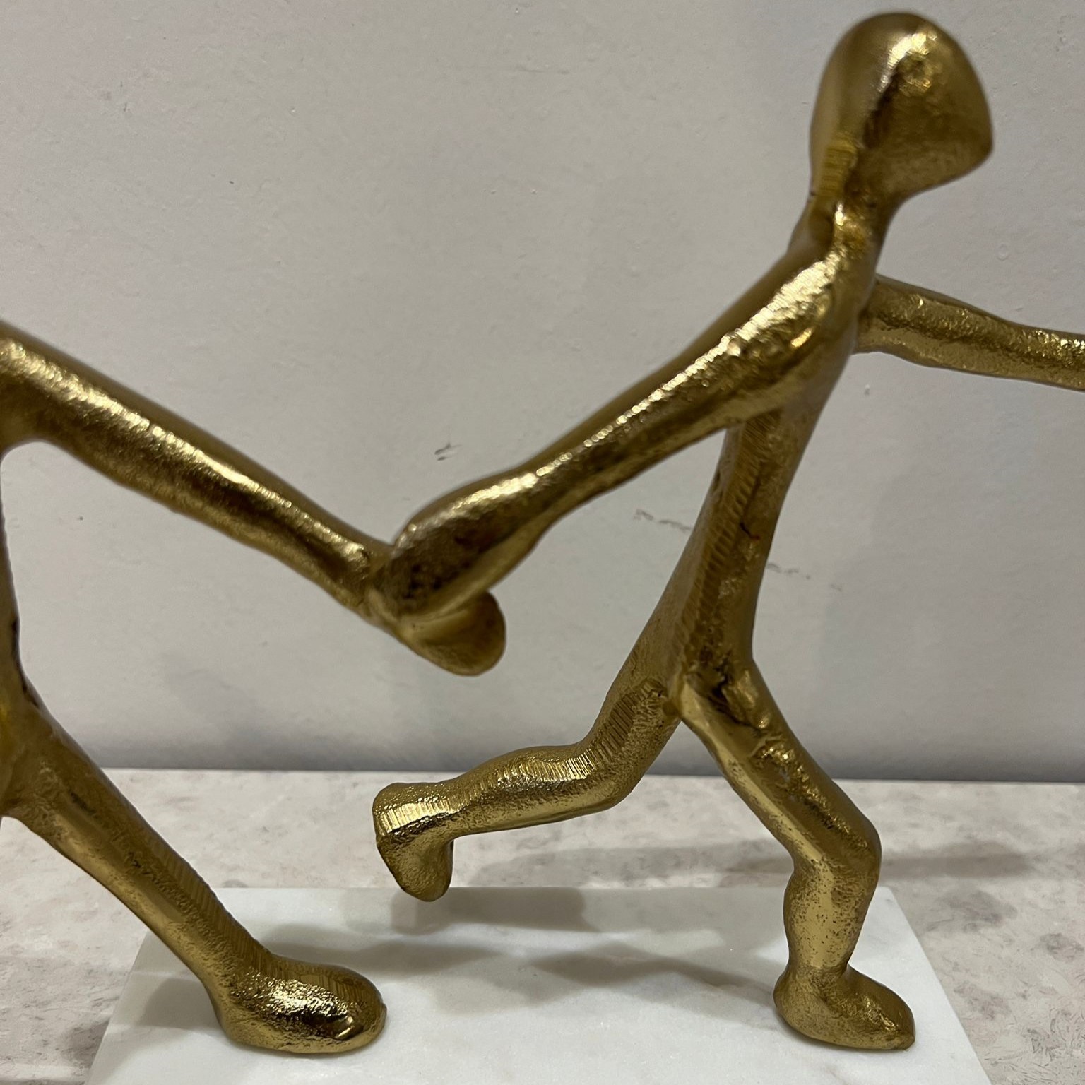 פסל זוג צוהל מזיקים ידיים מתכת זהב בסיס לבן פסל זוג צוהל מזיקים ידיים מתכת זהב בסיס לבן