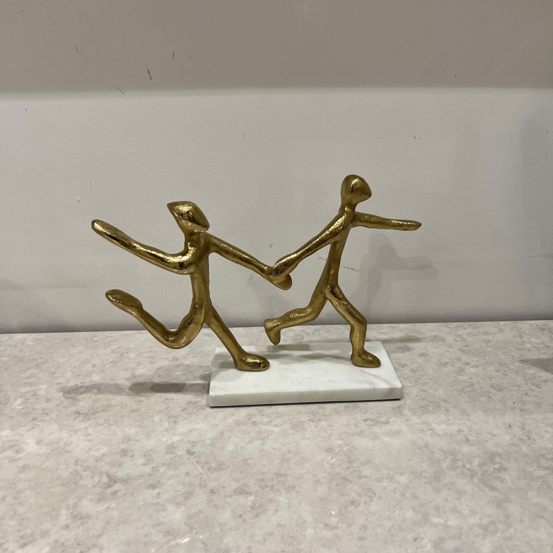 פסל זוג צוהל מזיקים ידיים מתכת זהב בסיס לבן פסל זוג צוהל מזיקים ידיים מתכת זהב בסיס לבן